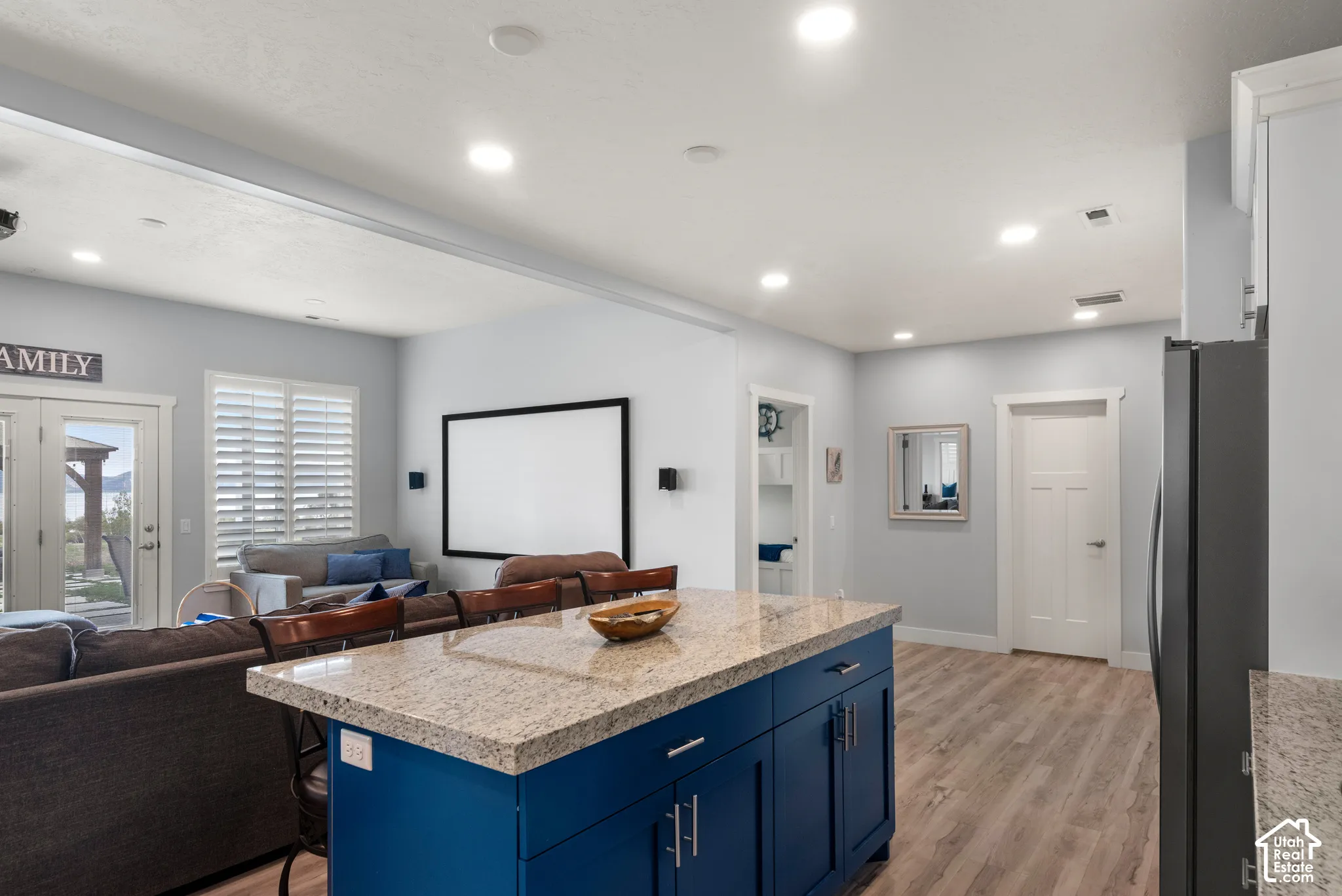Kitchen island with a granite countertop and blue cabinetry