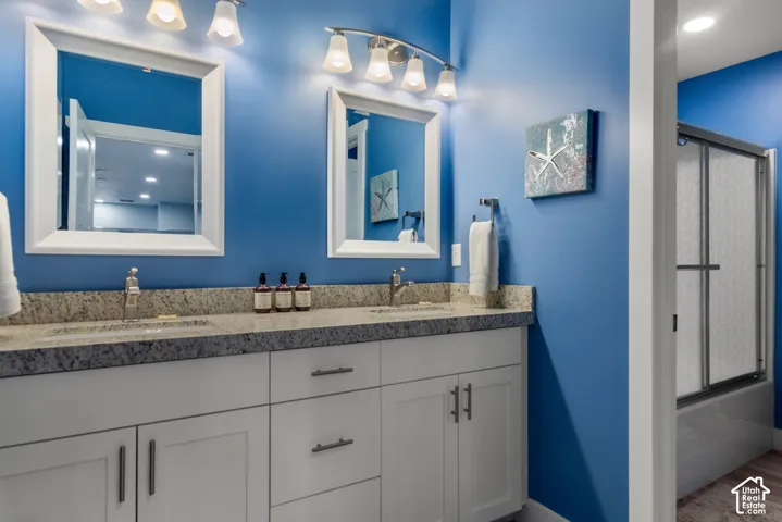 Dual vanity with white cabinetry, granite-style countertops, and undermount sinks