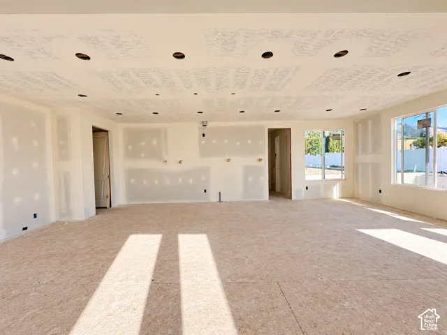 Recessed lighting, multiple windows, open concept layout, and unfinished drywall