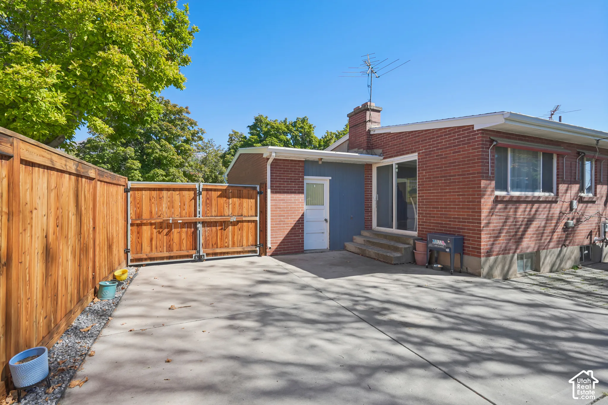 Brick exterior with a white trim, featuring a sliding glass door and a side entry door