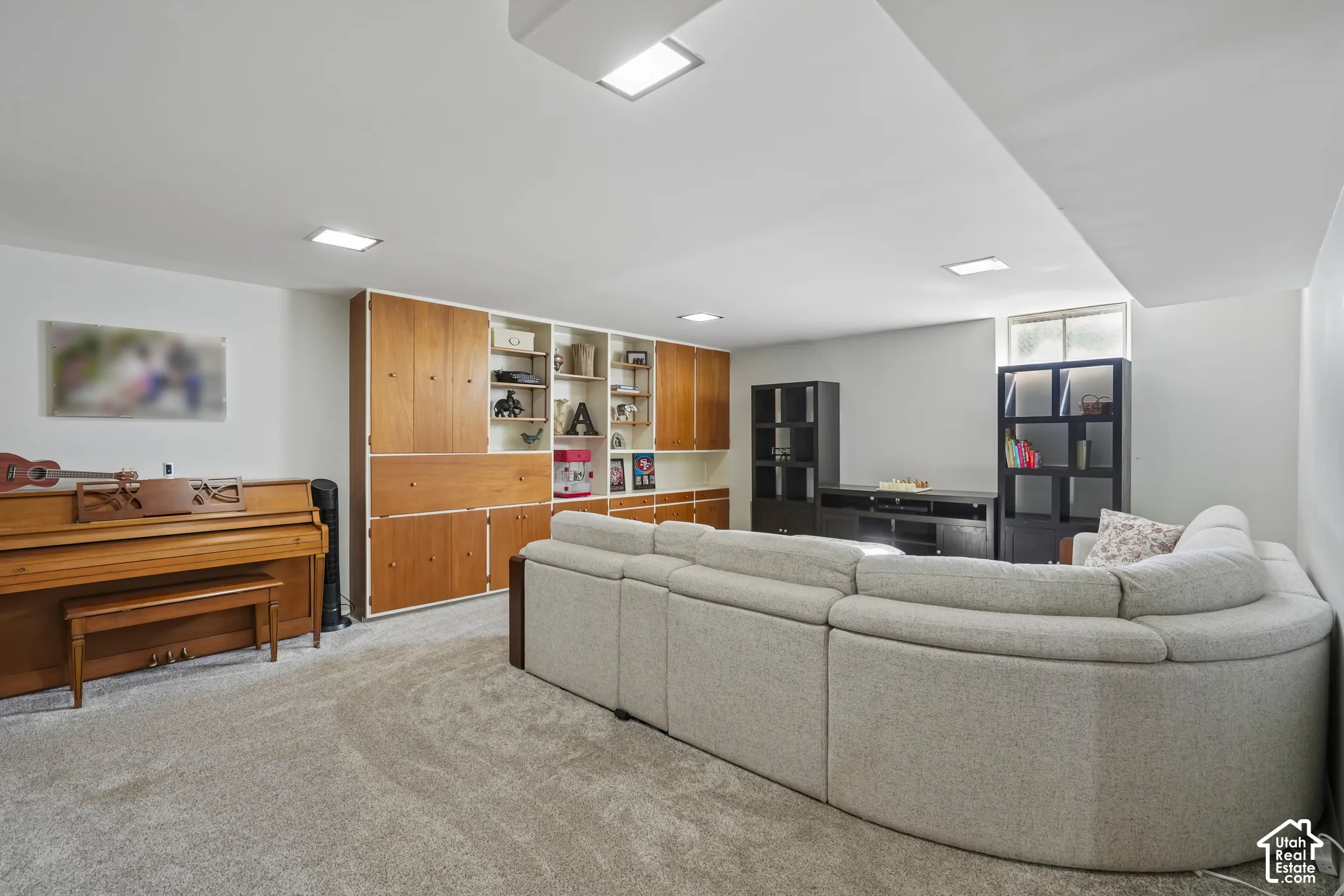 Wood-finish built-in shelving, recessed lighting, and soft carpet flooring