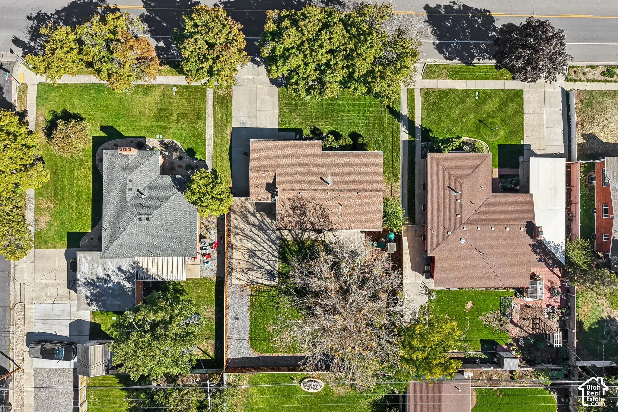 Expansive property featuring a gabled roofline, mature trees, and a paved driveway