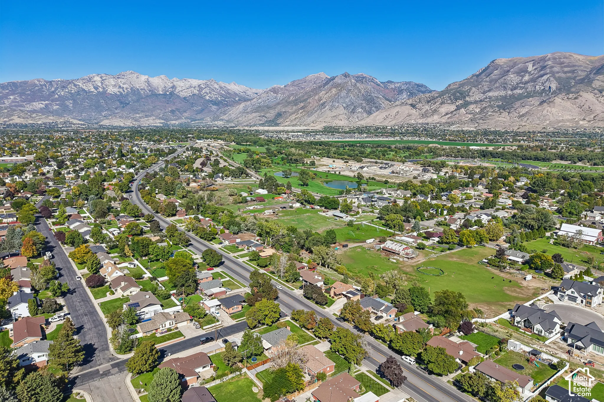 Expansive residential area featuring established homes, mature trees, and mountainous terrain