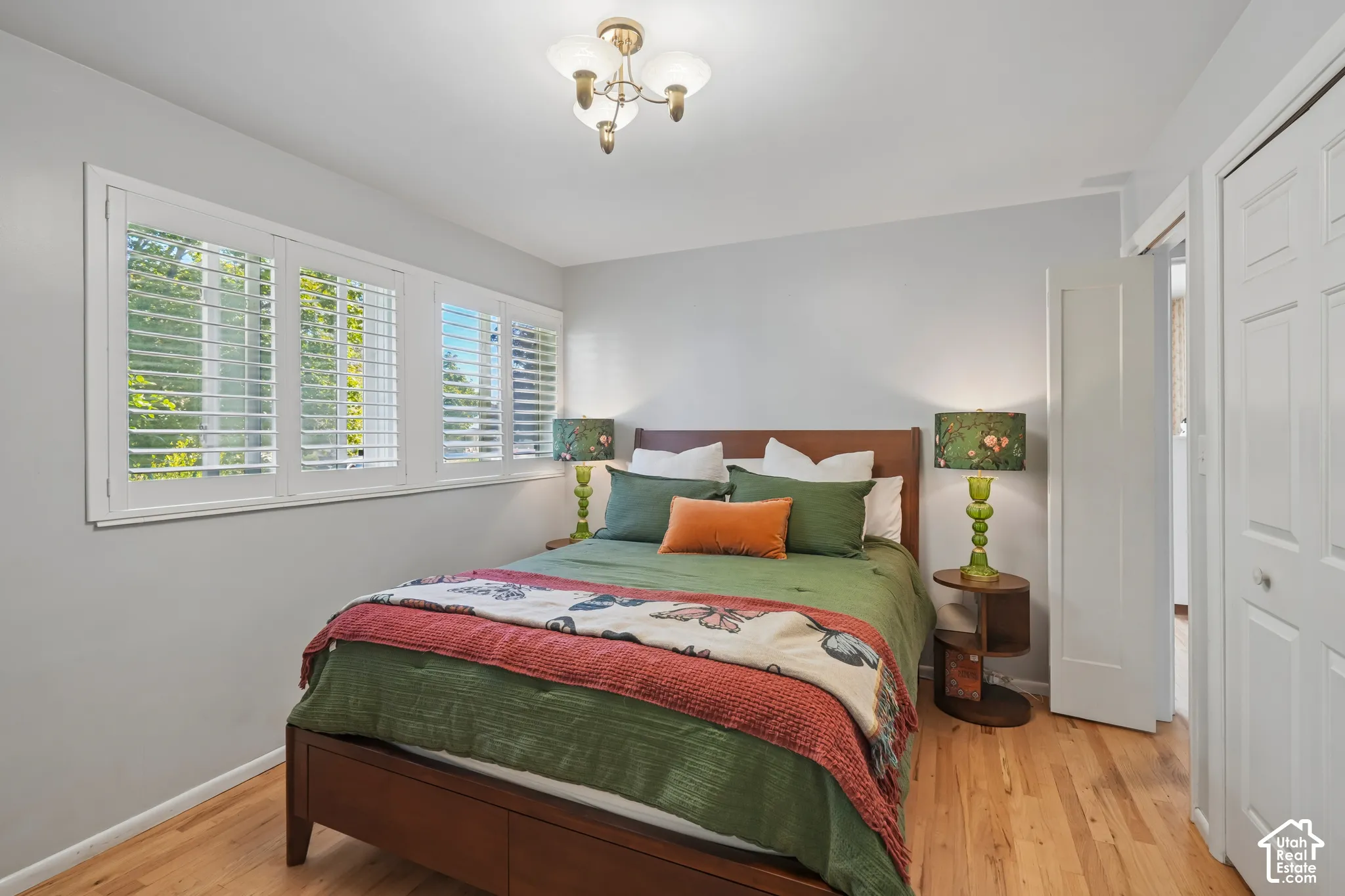 Hardwood-finish flooring, white window shutters, white walls, and a ceiling-mounted light fixture