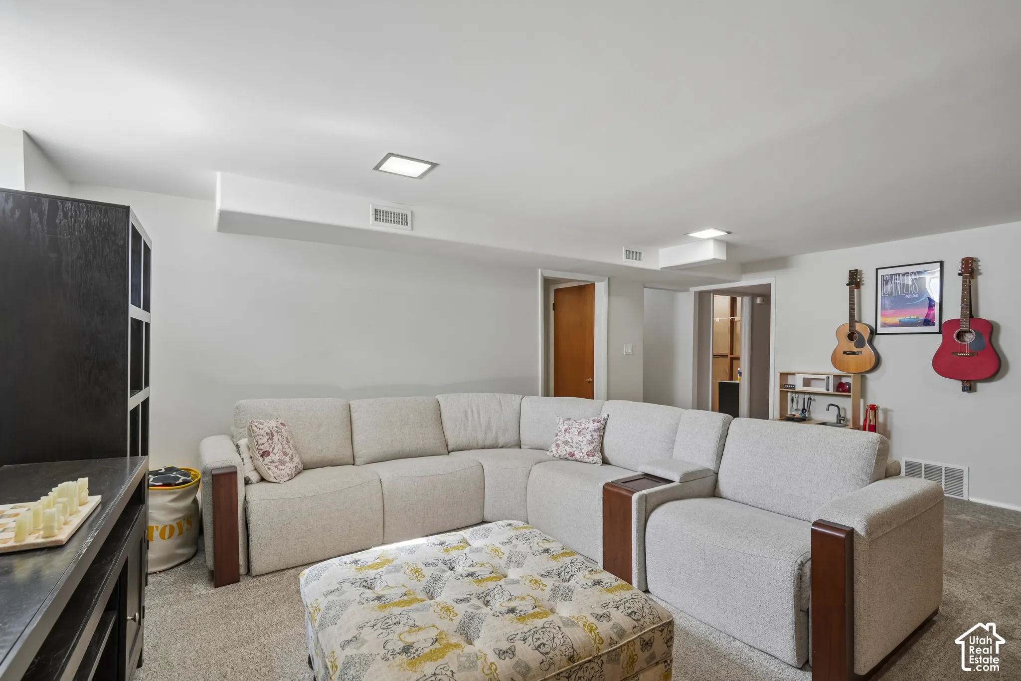 Recessed ceiling lighting, light gray wall paint, and exposed ductwork
