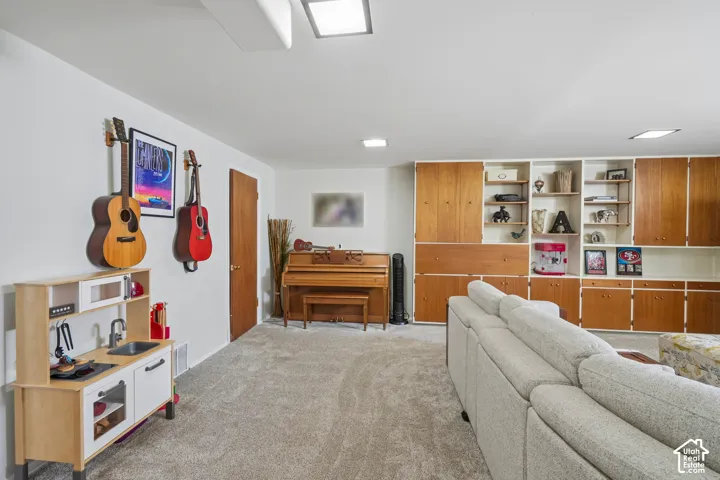 Built-in storage solutions with wood-finish cabinetry, recessed ceiling lighting, and light-colored carpeting