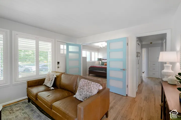 Hardwood flooring throughout, white plantation shutters, and light blue interior doors with frosted glass panels