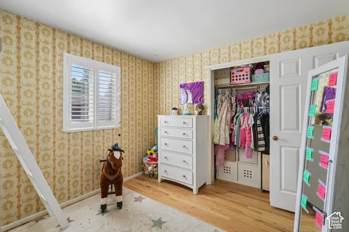 Hardwood-style flooring and a window with plantation shutters