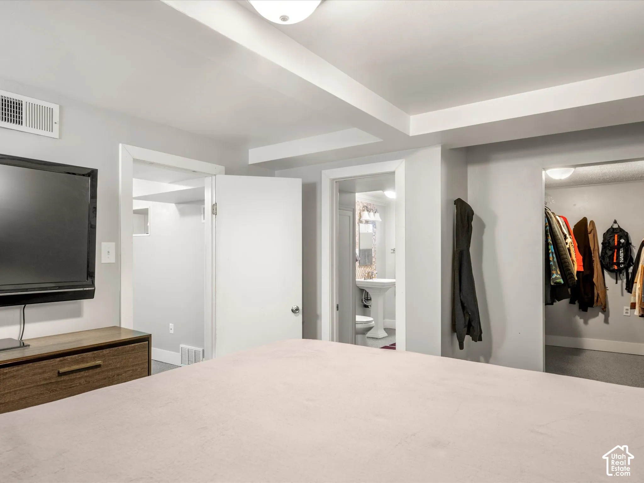 Recessed ceiling with exposed beams, light gray wall paint, and white trim