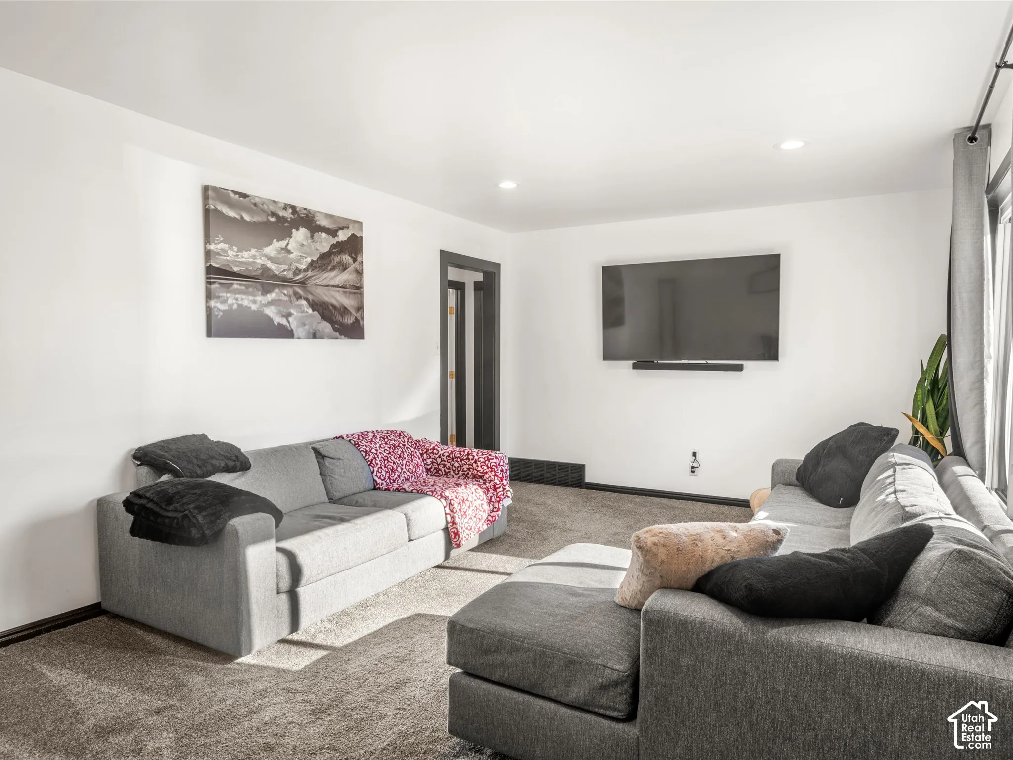 Recessed lighting, wall-mounted television, dark trim, and light wall finishes