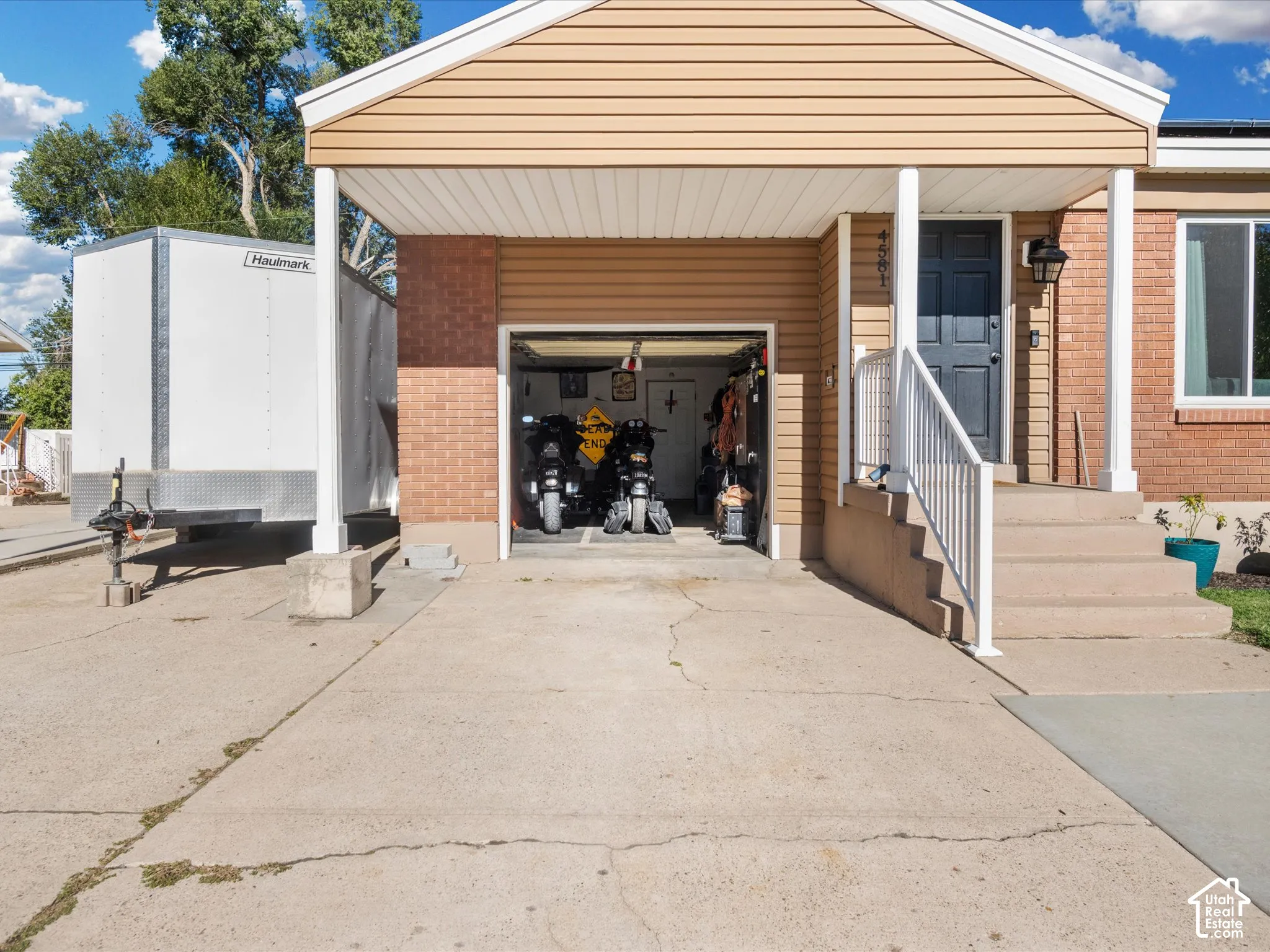 Front exterior with tan siding and brick accents