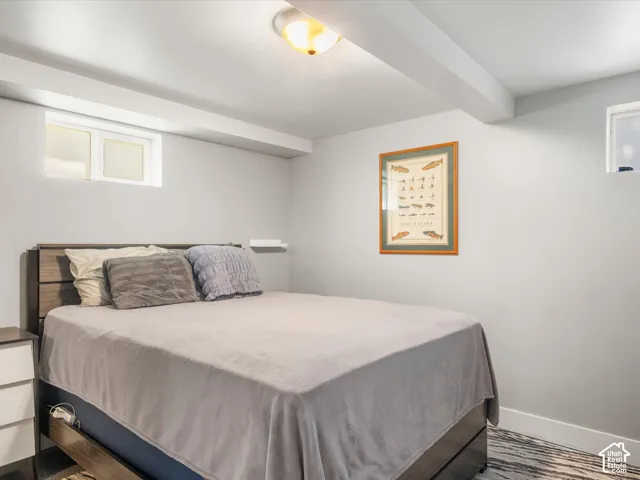 Recessed windows, ceiling-mounted light fixture, light gray wall paint, and white ceiling beams