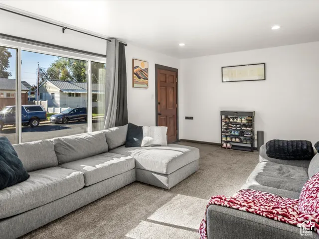 Bright living area featuring sliding glass doors, recessed lighting, and wood-finish entry door