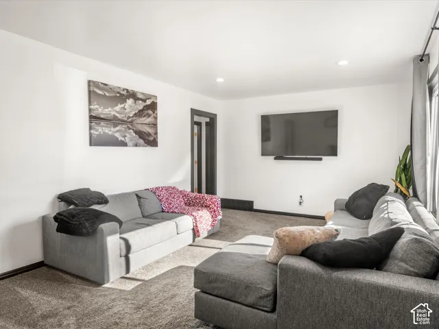 Recessed lighting, wall-mounted television, dark trim, and light wall finishes