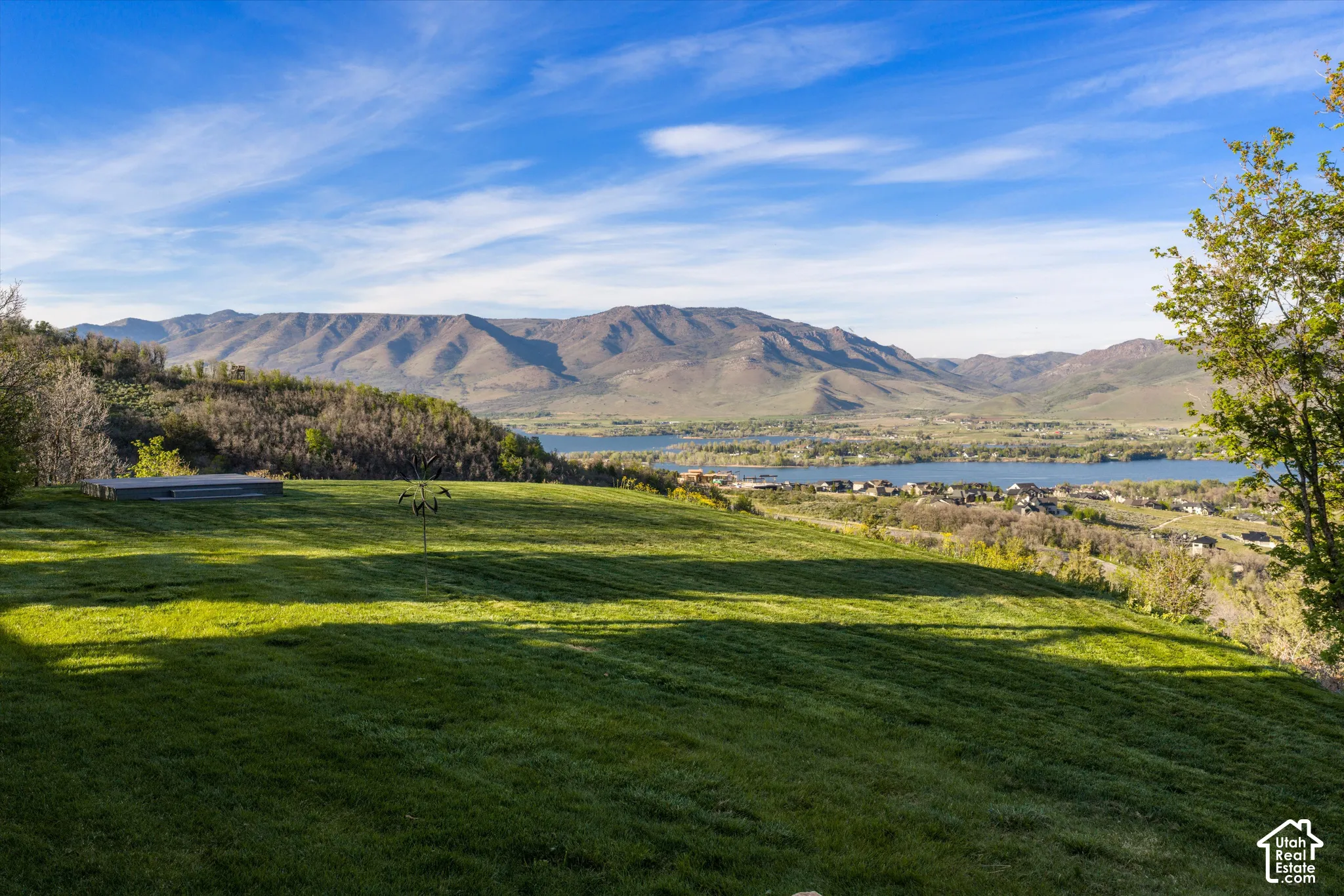 Expansive green lawn with mountain and lake scenery