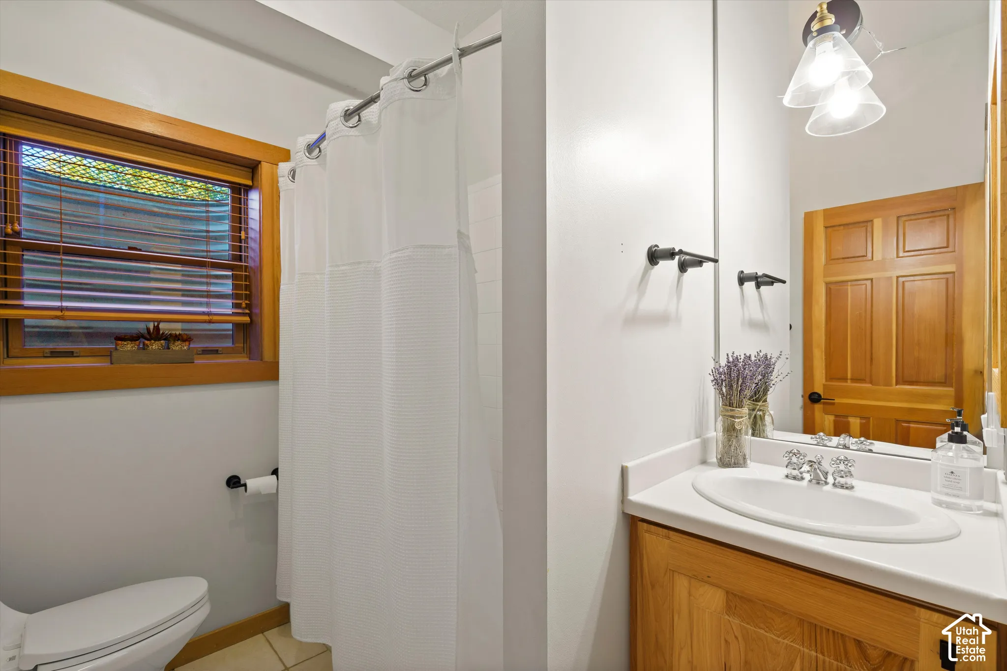 Wood-finish vanity with white countertop, chrome faucet, and integrated sink