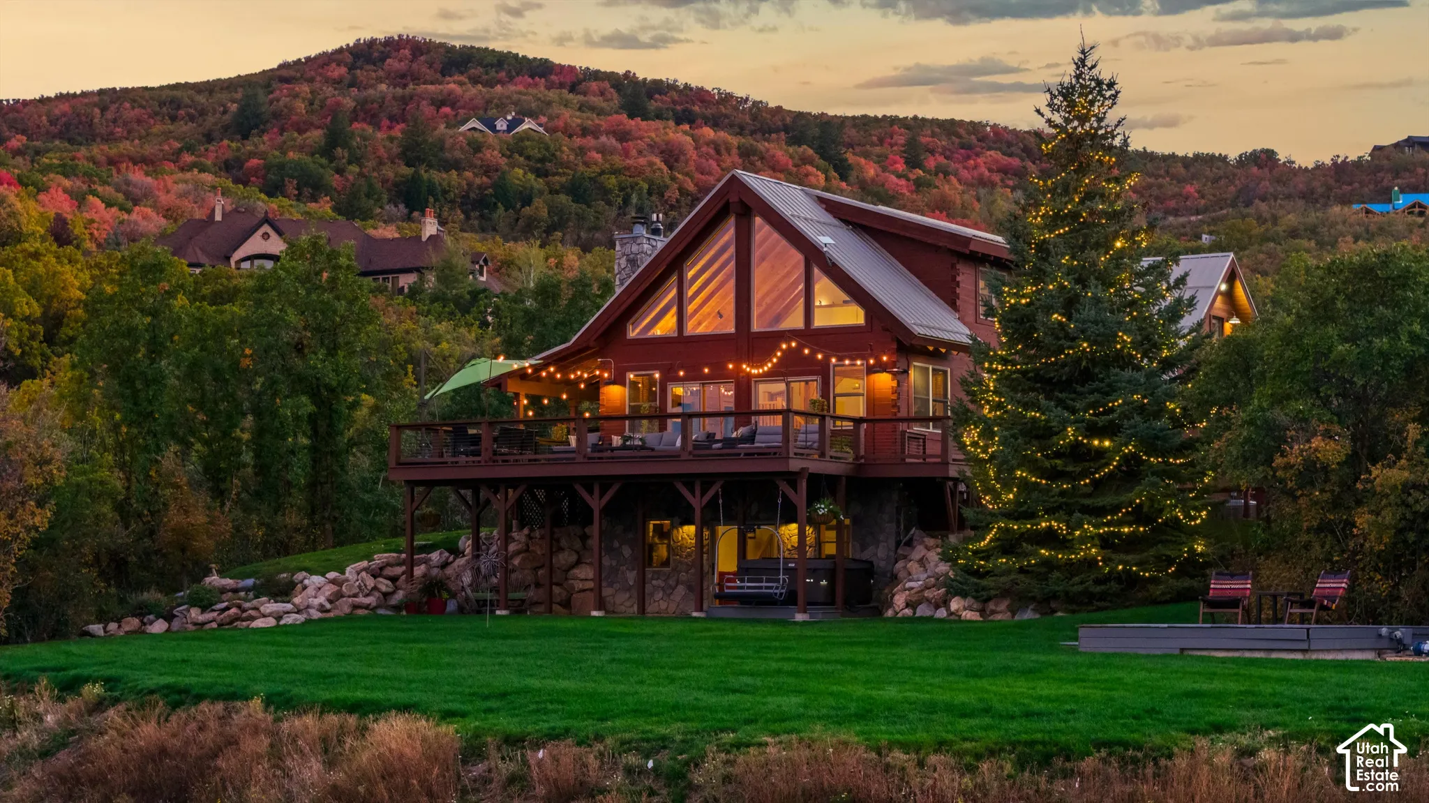 Two-story log cabin exterior with stone foundation and expansive wood decking