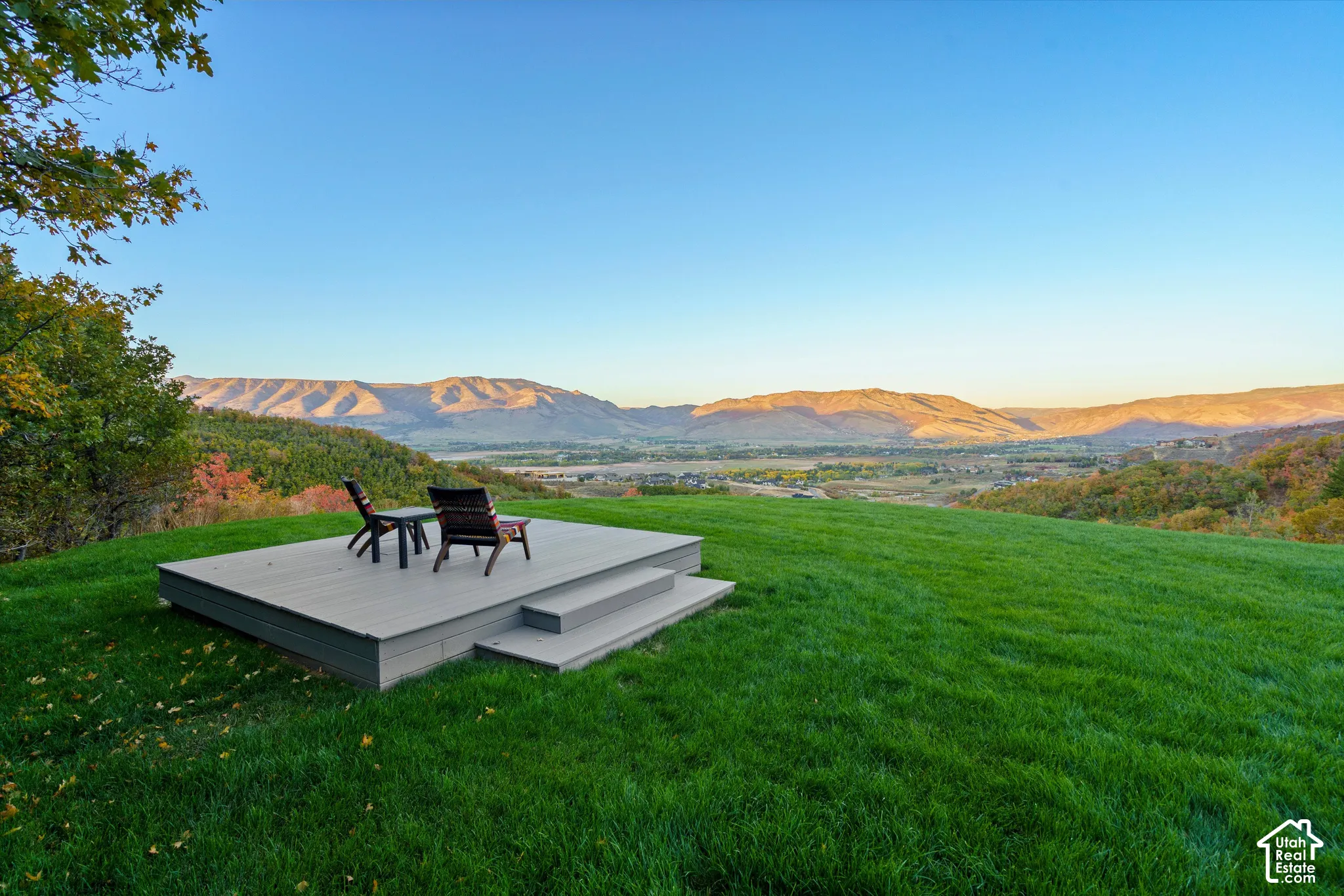 Expansive green lawn with a composite deck and two steps