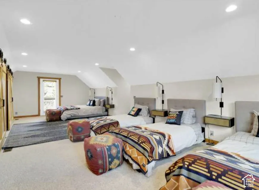 Recessed ceiling lighting, vaulted ceiling, wood-finish barn doors, wood-framed exterior door, wall-mounted light fixtures