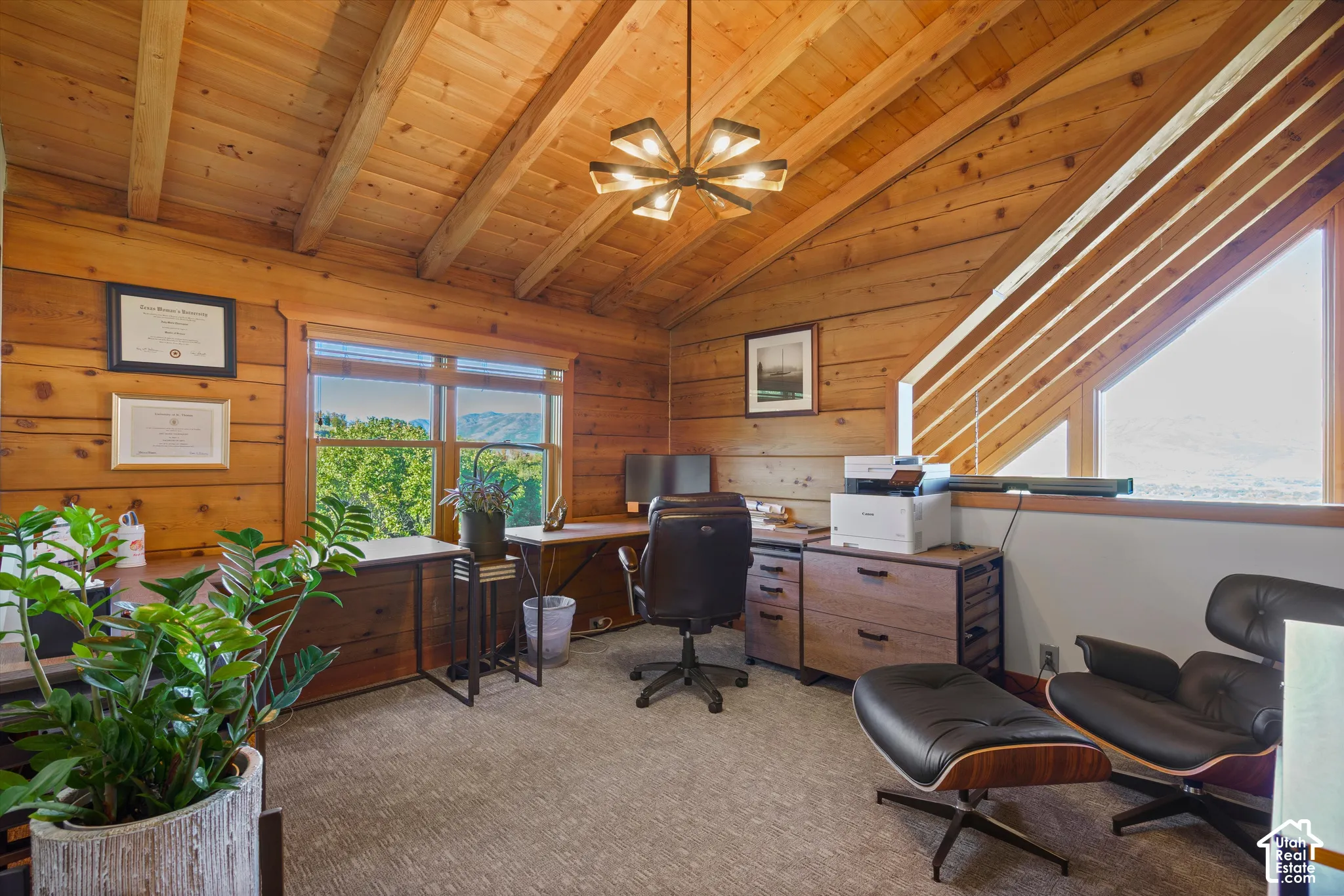Vaulted wood-paneled ceiling with exposed beams, wood-plank walls, and a modern chandelier