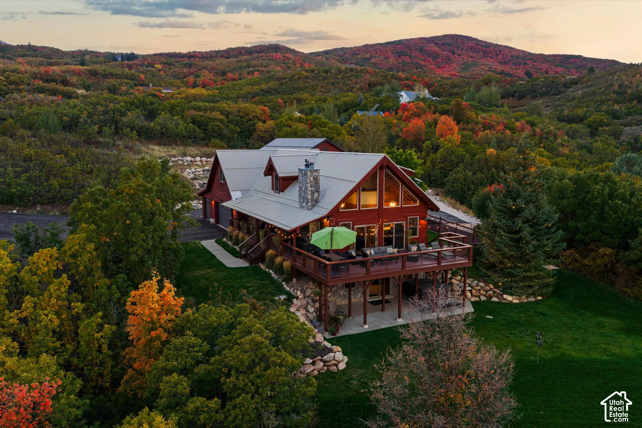 Red wood-sided home with a metal roof and stone chimney