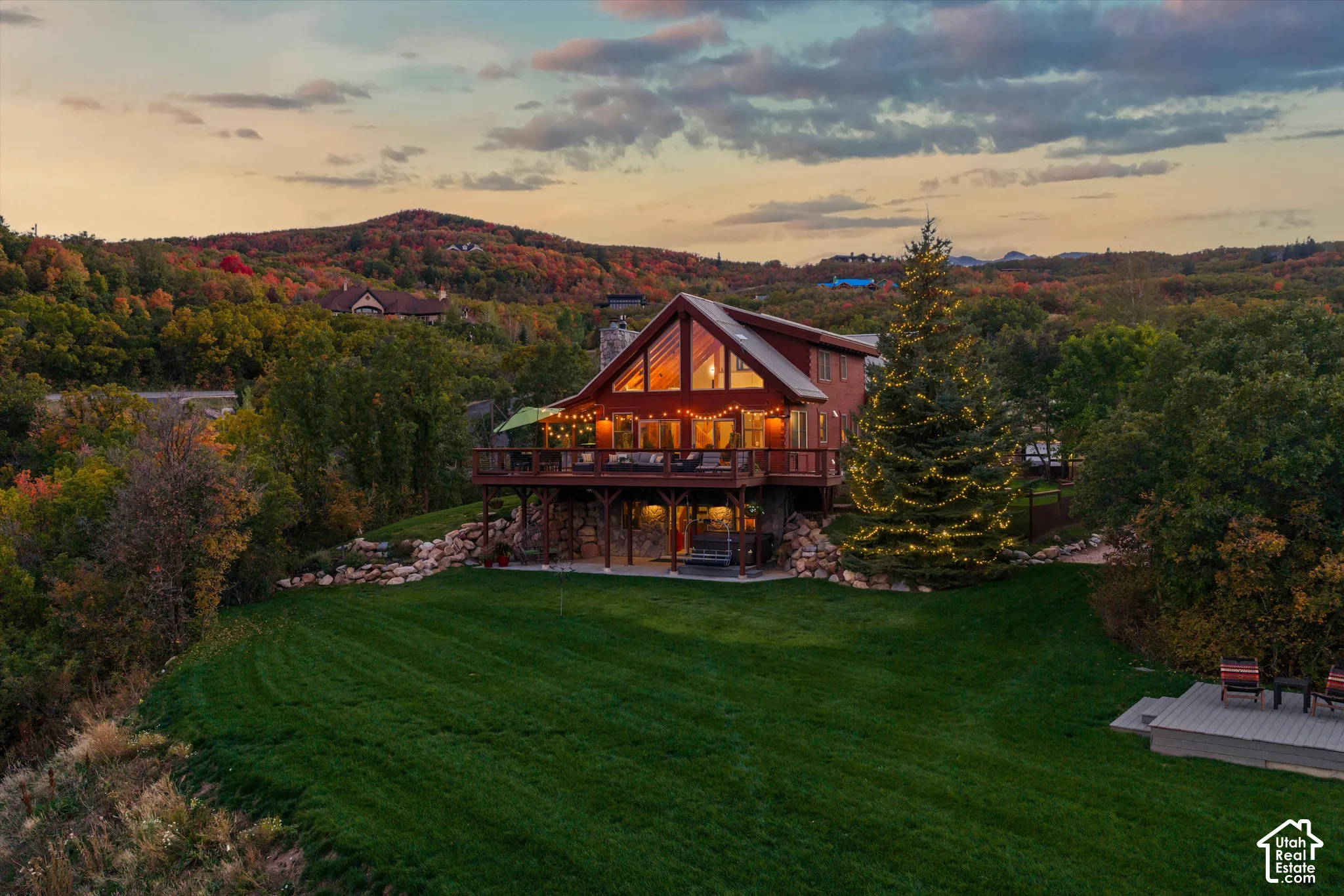 Contemporary home with a peaked roofline, expansive deck, and a lower-level patio