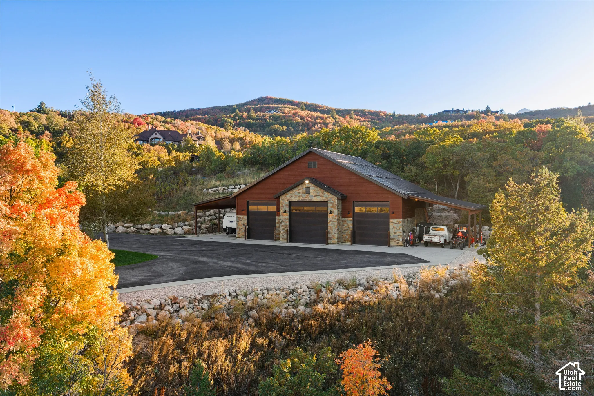 Stone and wood-sided outbuilding with three garage bays