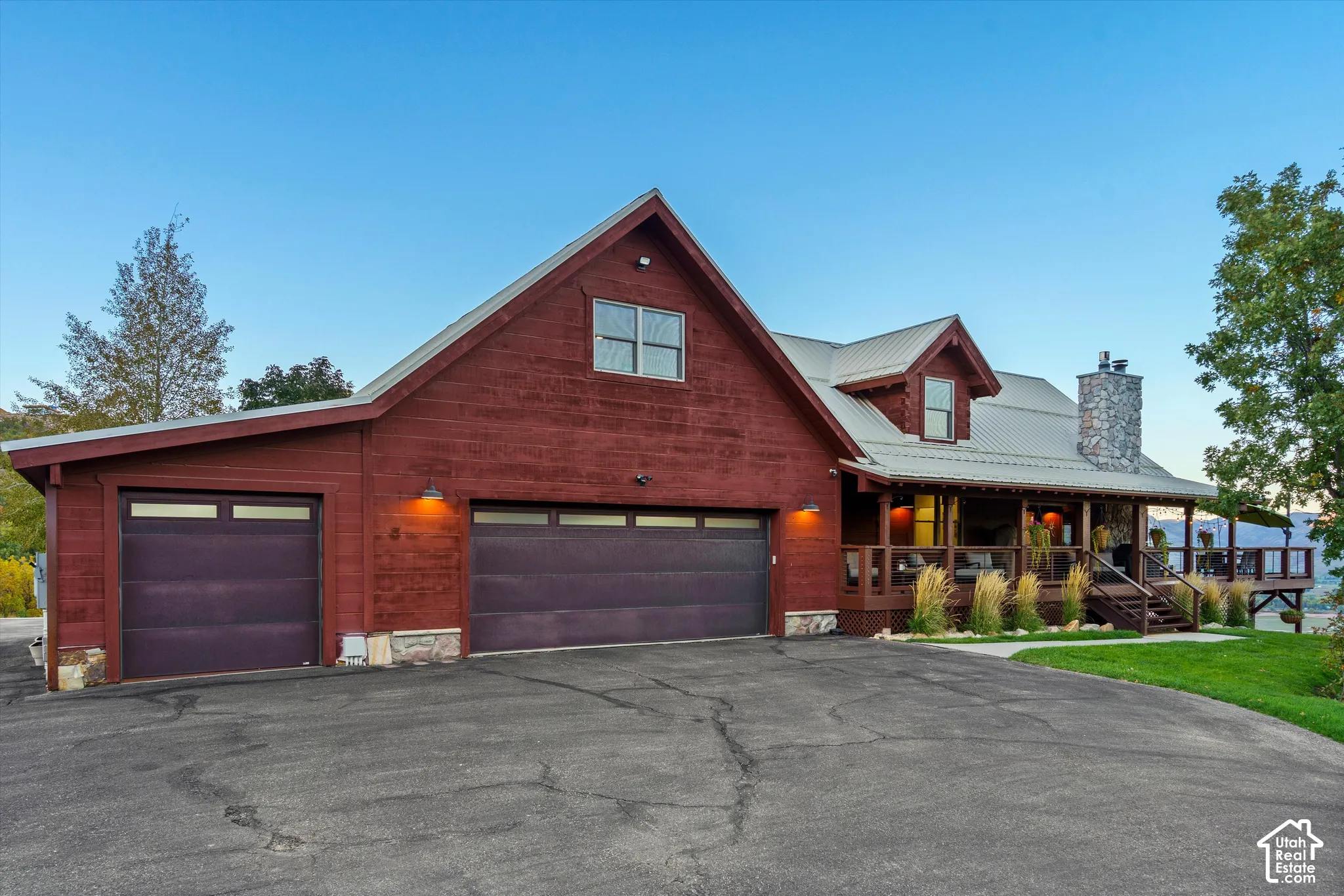 Red-toned siding exterior with a metal roof and stone chimney