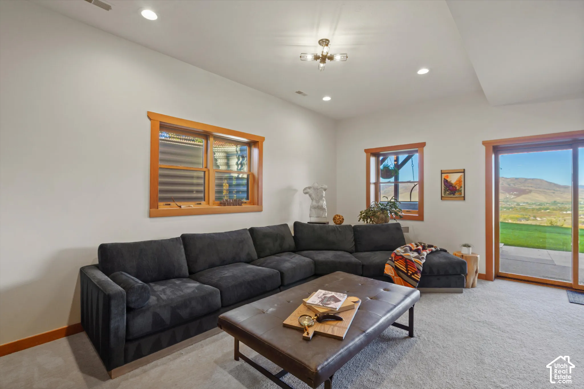 Recessed lighting, wood-trimmed windows, glass sliding door, and neutral carpeting