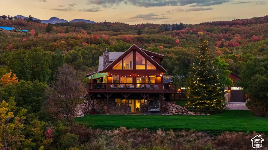Wood-sided home with a stone foundation, A-frame architecture, and a spacious deck