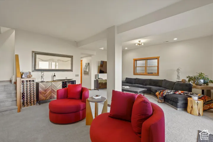 Carpeted living space featuring recessed lighting, a built-in wine rack, and a wood-framed window with horizontal blinds