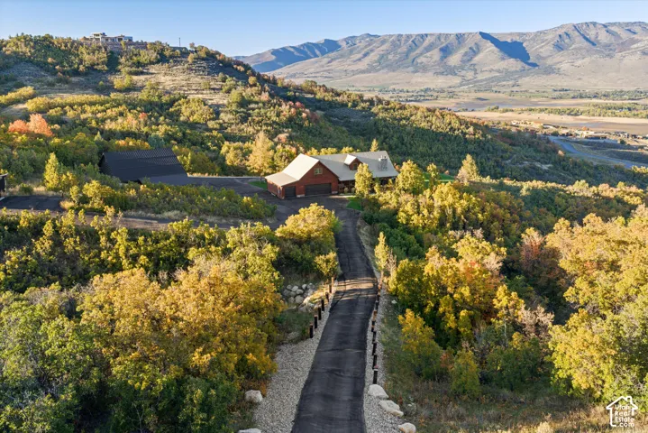 Expansive property featuring a paved driveway, two-story residence with attached garage, and a secondary structure