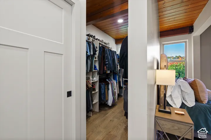 Walk-in closet featuring wood-finish flooring and integrated shelving