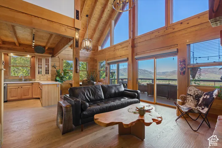 Vaulted wood-paneled ceiling, large windows, wood-finish flooring, built-in cabinetry, mountain scenery