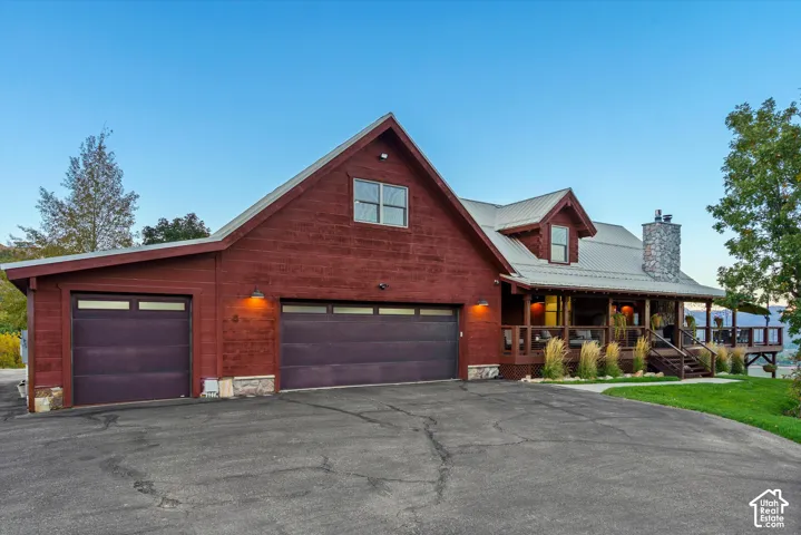 Red-toned siding exterior with a metal roof and stone chimney