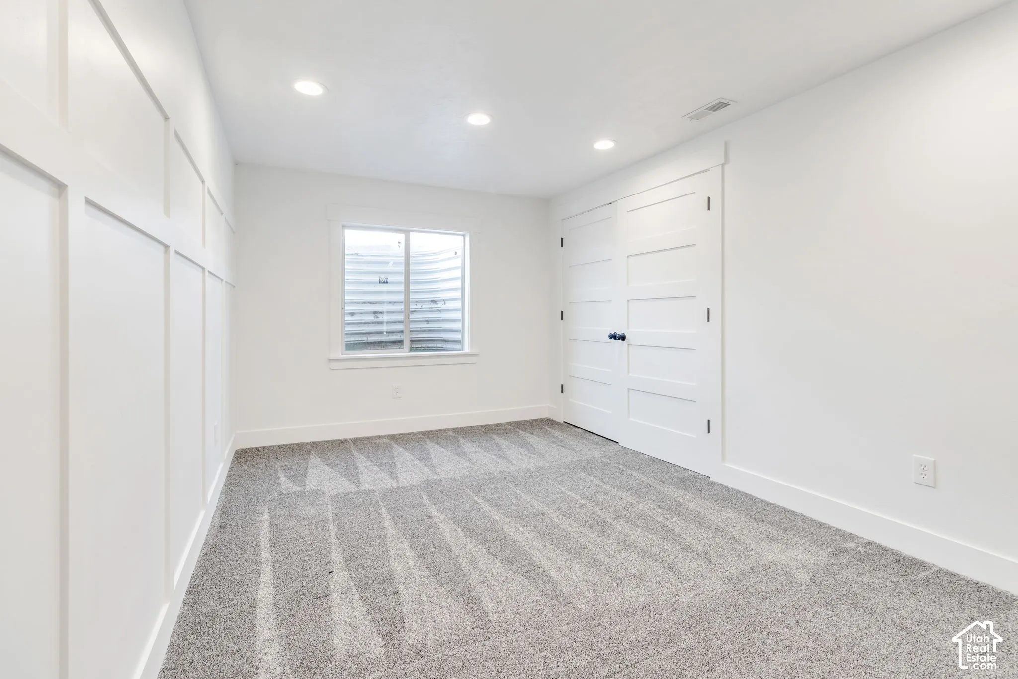 Recessed lighting illuminates the room, featuring a board and batten accent wall