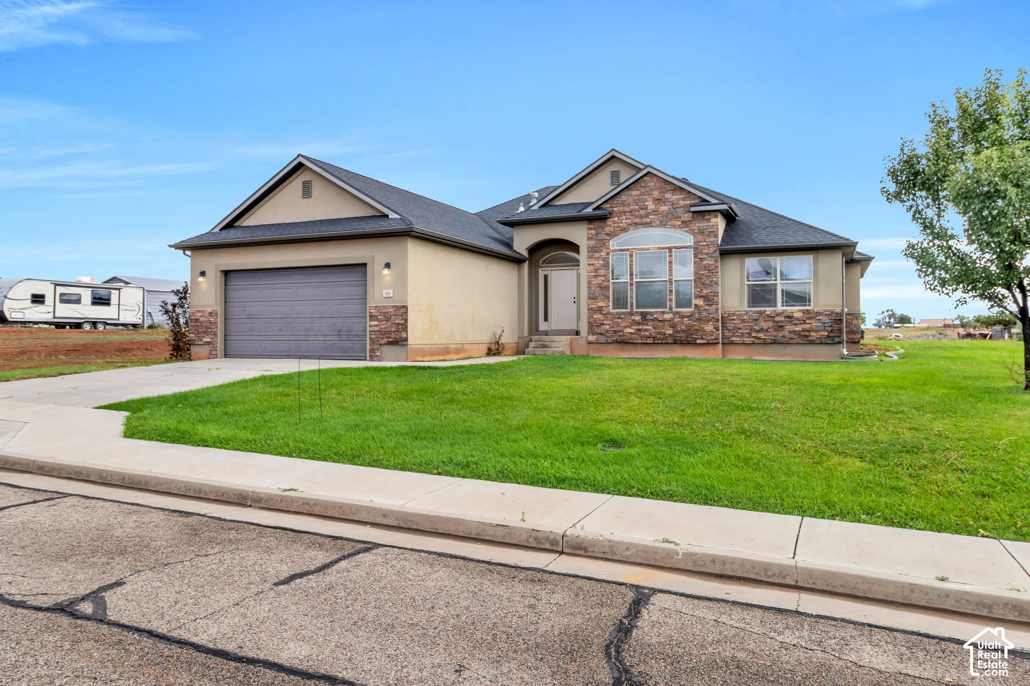 Stucco and stone exterior with an arched entry and integrated garage