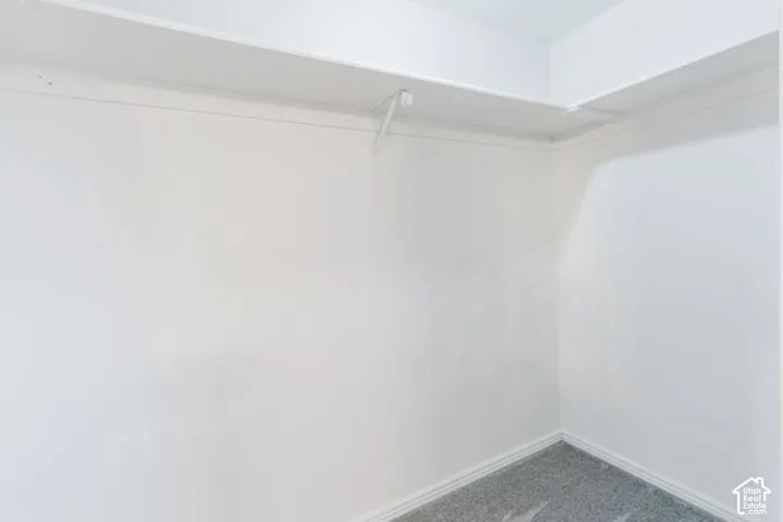 White wall finishes, upper shelving, and a hanging rod