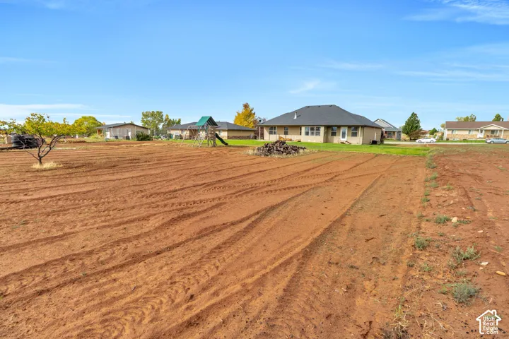 Expansive undeveloped lot featuring rich red soil and scattered natural vegetation