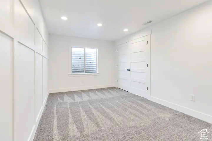 Recessed lighting illuminates the room, featuring a board and batten accent wall