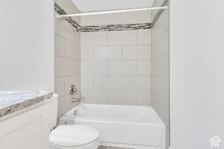 White subway tile surround with a decorative accent band, complete with a chrome shower fixture