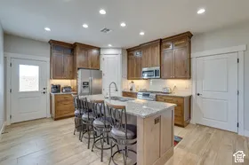 Kitchen with wood-finish flooring, recessed lighting, and a center island featuring a granite countertop