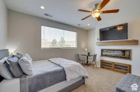 Recessed lighting, ceiling fan, built-in electric fireplace, wall-mounted display shelf, and built-in wood-finish cabinetry