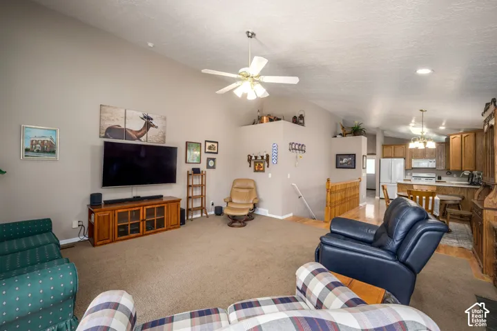 Vaulted ceilings, ceiling fan, wood-finish flooring, recessed lighting, and kitchen with wood cabinetry