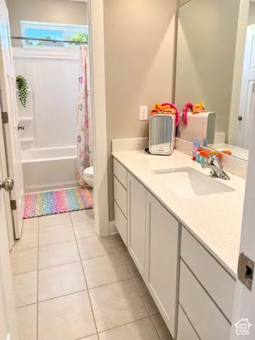 White shaker-style vanity with a light-toned countertop and integrated sink