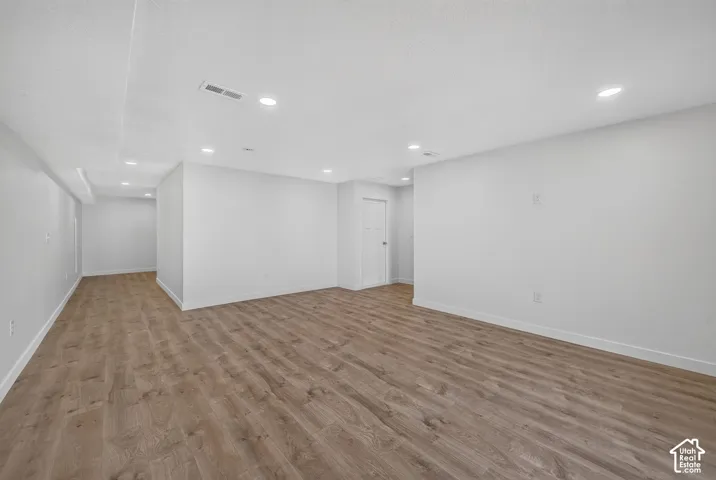 Spacious living room featuring wood-finish flooring & recessed lighting