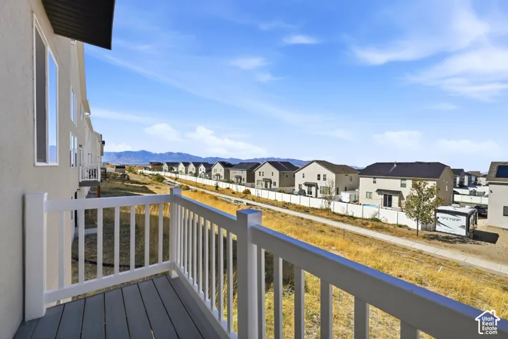 Private balcony with composite decking, white railing, and stucco exterior