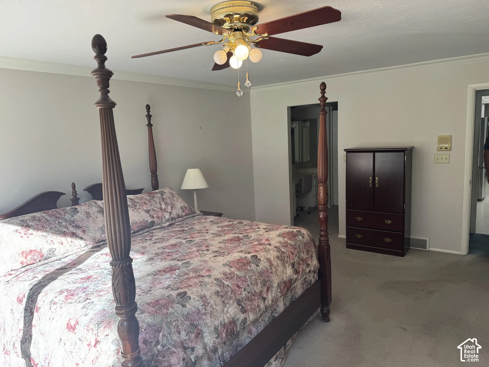 Carpeted room with crown molding and ceiling fan