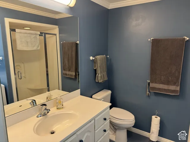 Vanity with a white countertop and integrated sink, chrome faucet, wall-mounted mirror, and a shower enclosure with a clear glass door