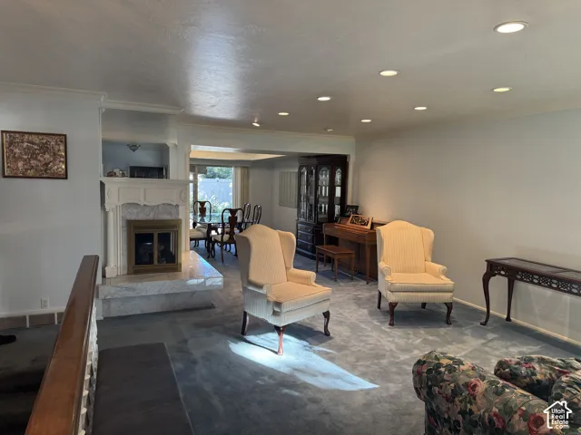 Living area featuring recessed lighting, a fireplace with a white mantel and marble-look surround, and carpeting
